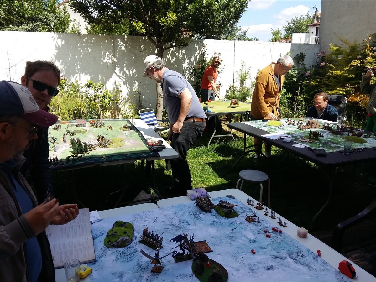 Partie de figurines avec decors sur une grande table de jeu