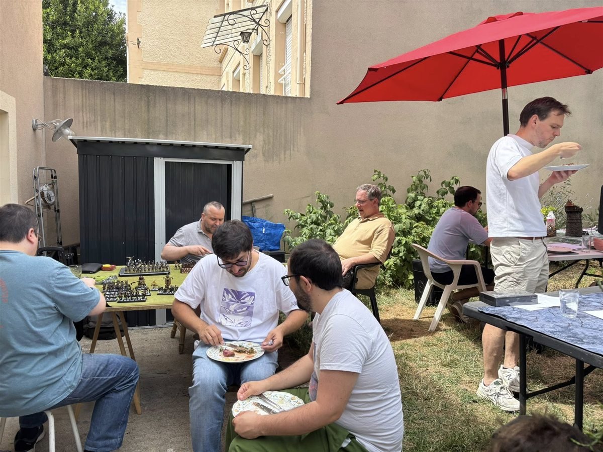 Pause et echanges entre passionnes pendant une partie de figurines